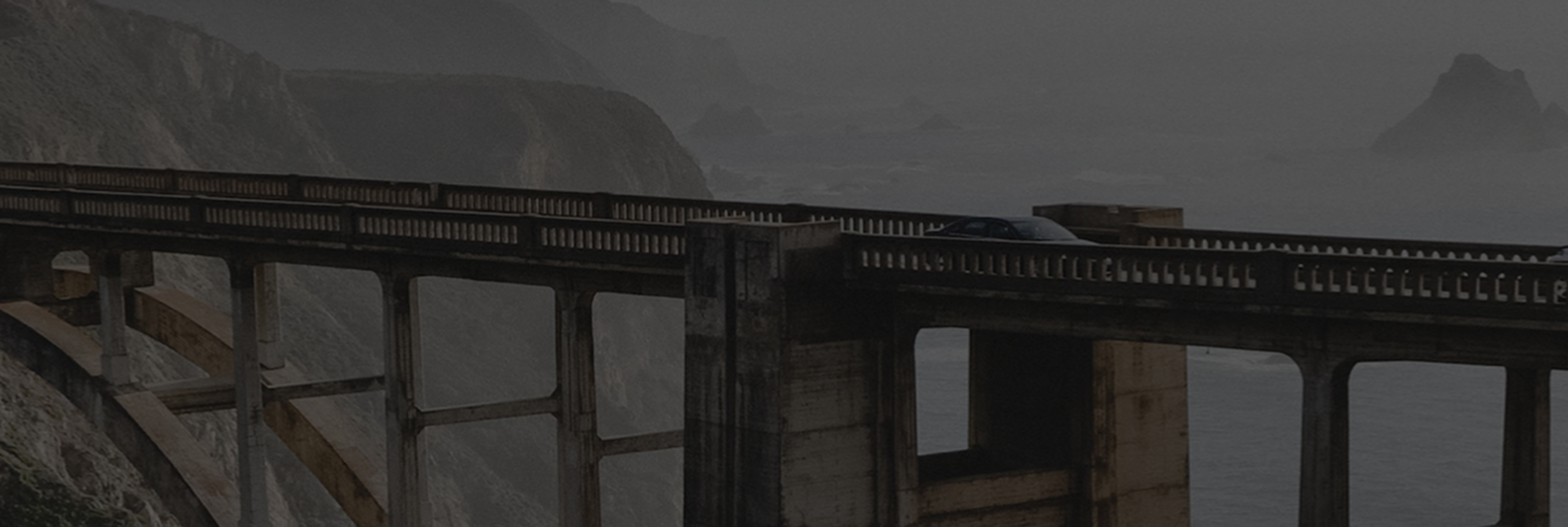 car going over a bridge in foggy weather